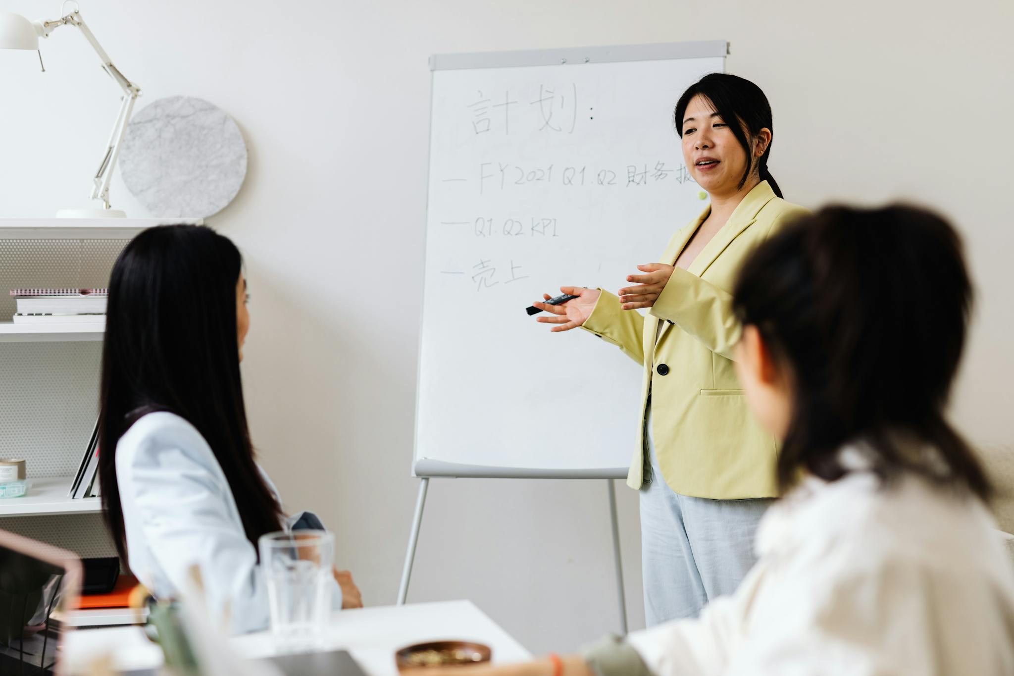 Confident businesswoman presenting strategy to colleagues in a modern office setting.